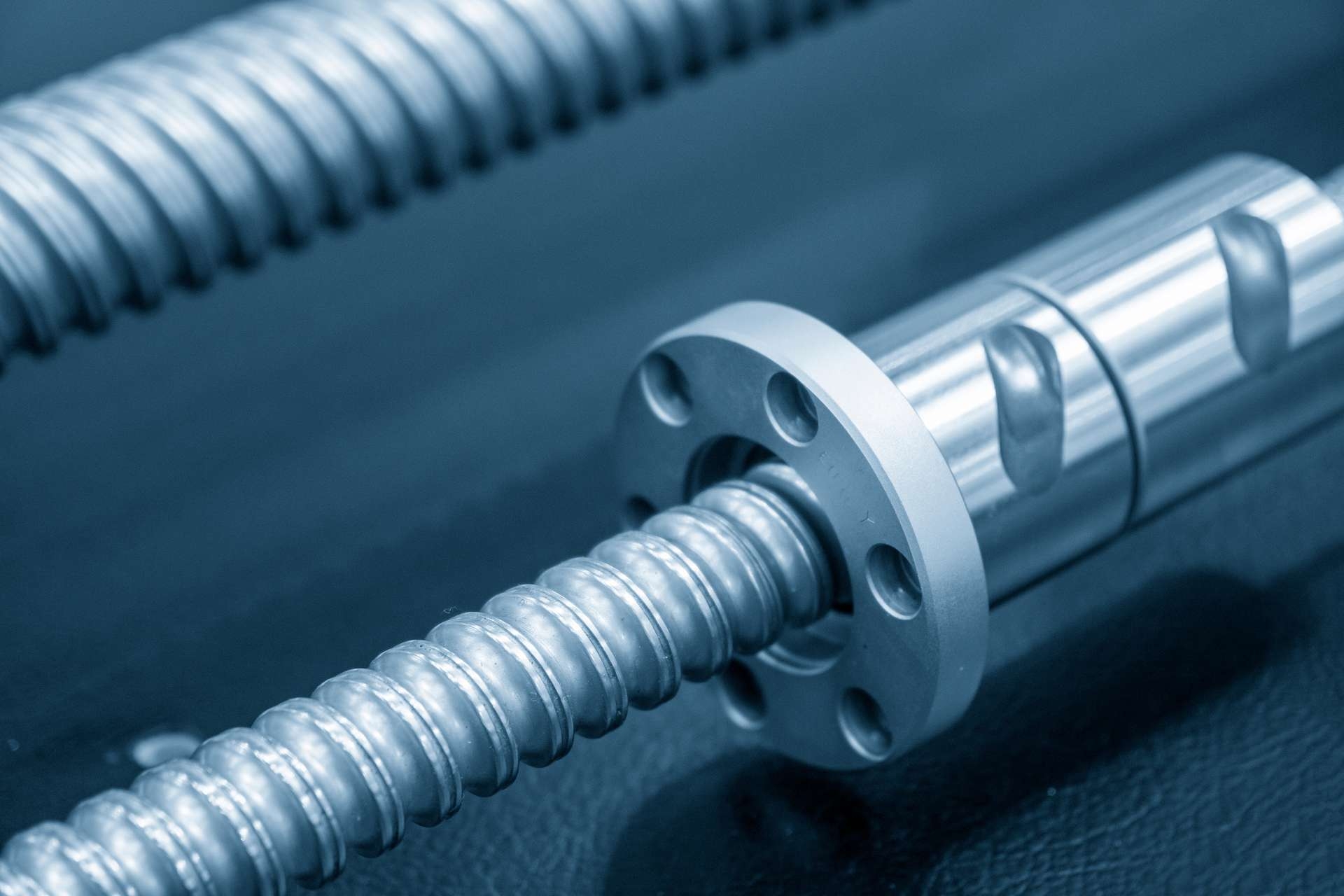 How do different ball screw designs impact load distribution across the screw?