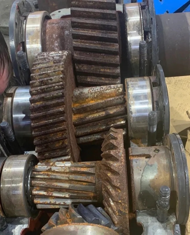 What are the advantages and limitations of using acoustic emission testing for crack detection in gearbox gear teeth?